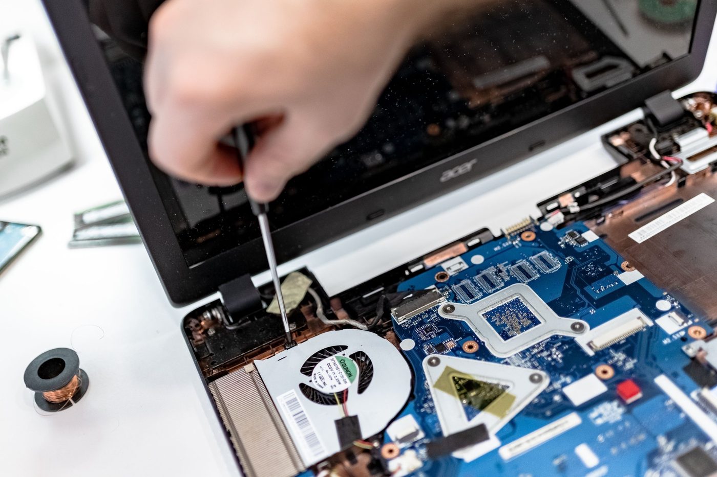 Technician repairing the inside of a laptop on-site